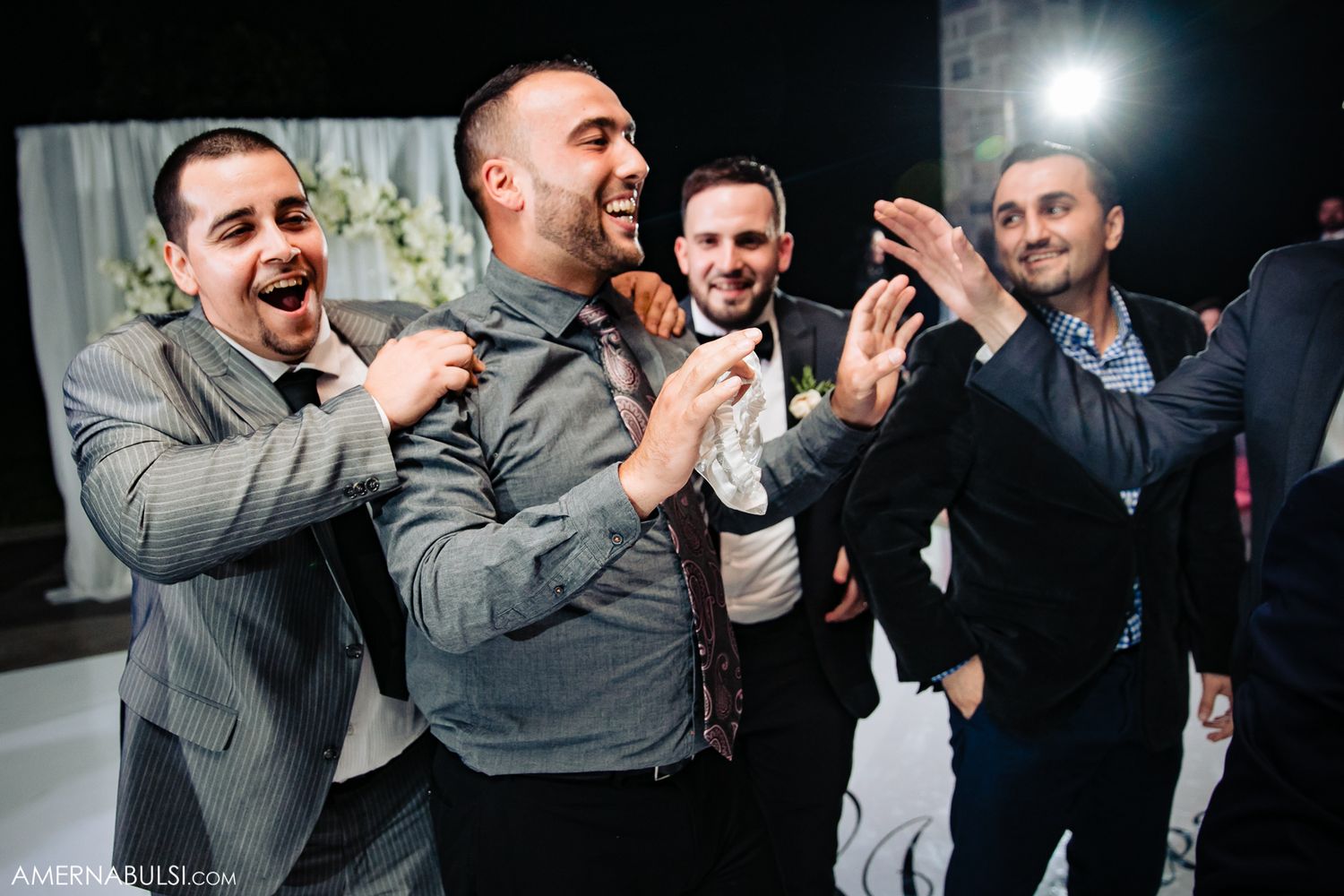 Energetic party scene with guests celebrating and dancing in formal attire.