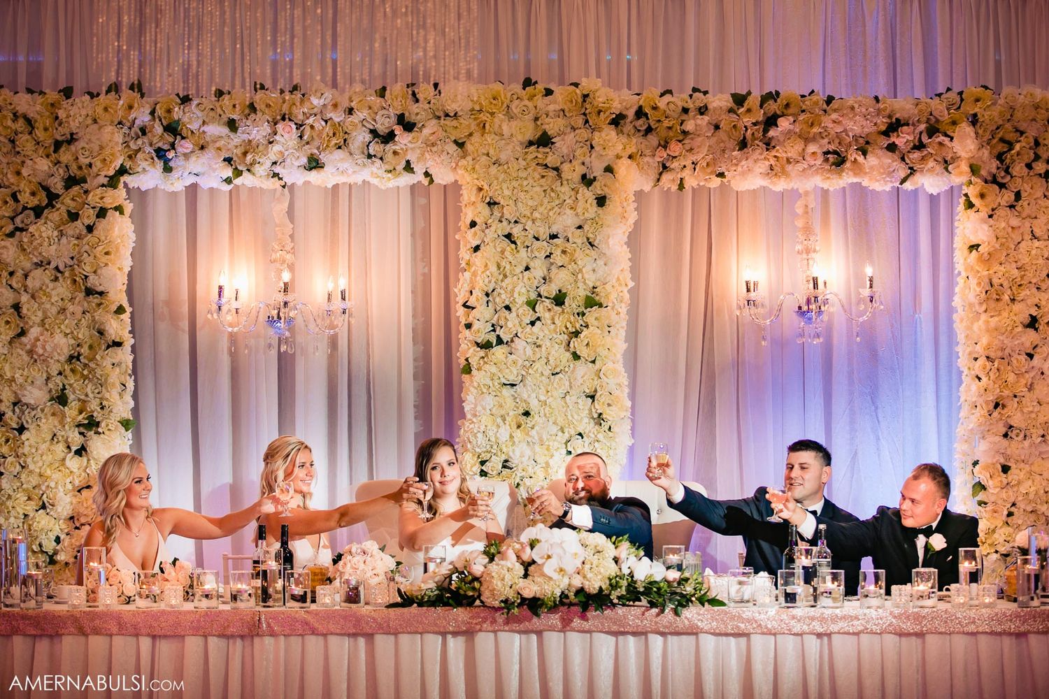 Elegant wedding reception hall decorated with floral arrangements and chandeliers.