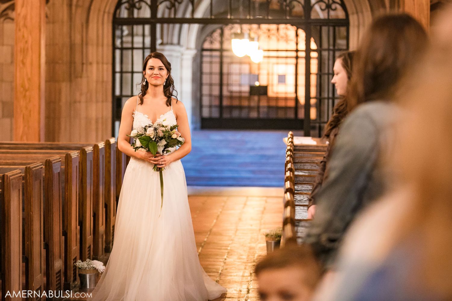 Church wedding ceremony with stone archways and natural light streaming through windows.