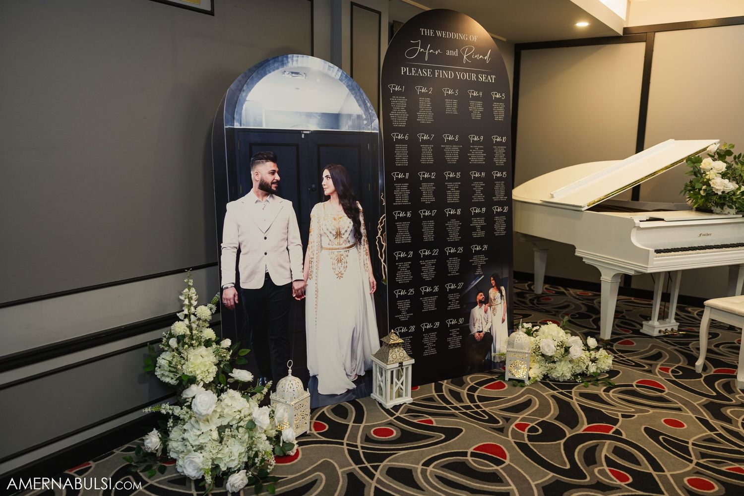 Wedding venue setup with a white piano, floral arrangements, and photo backdrop display.