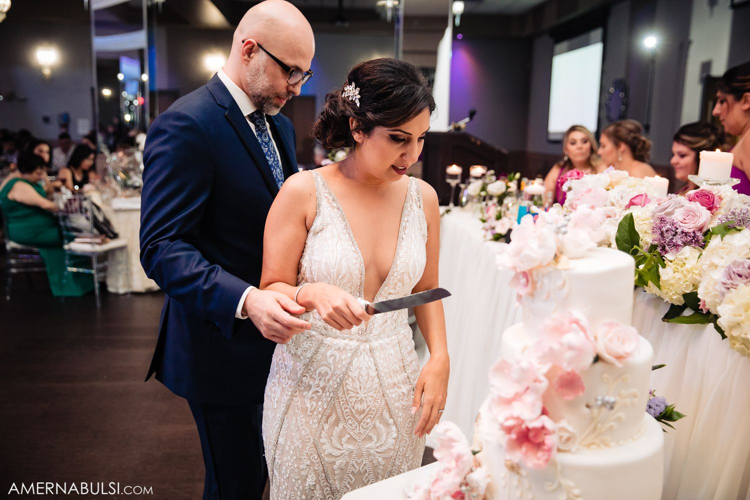 Wedding reception venue decorated with pink floral centerpieces and elegant table settings.
