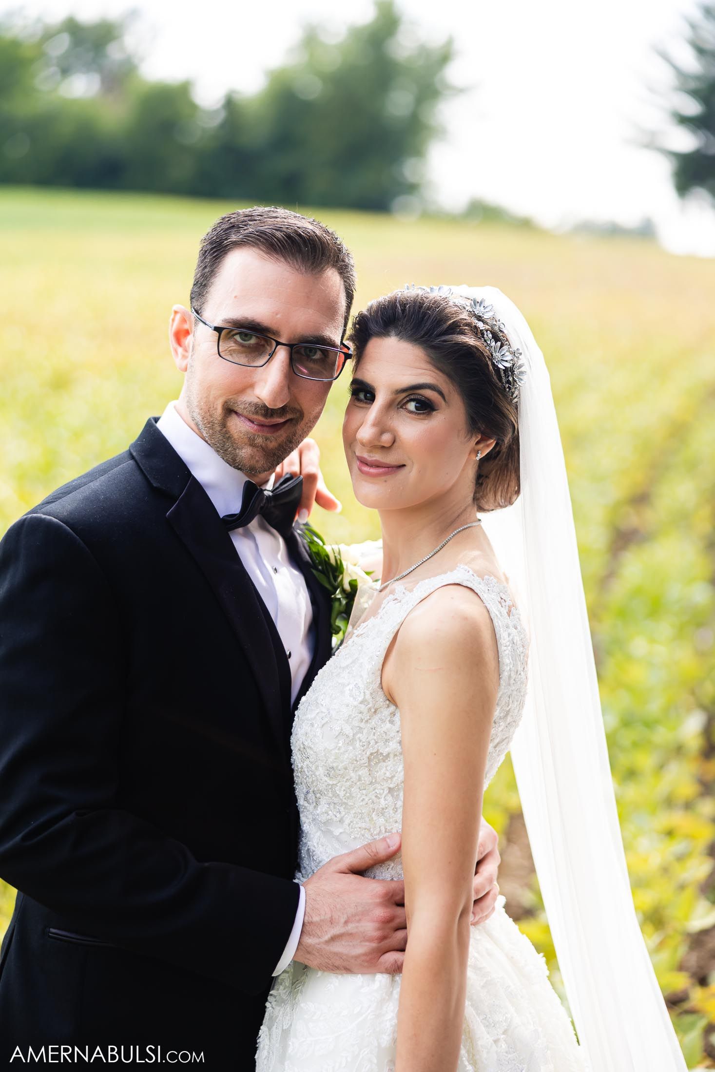 Romantic outdoor wedding portrait in a sunlit summer field.