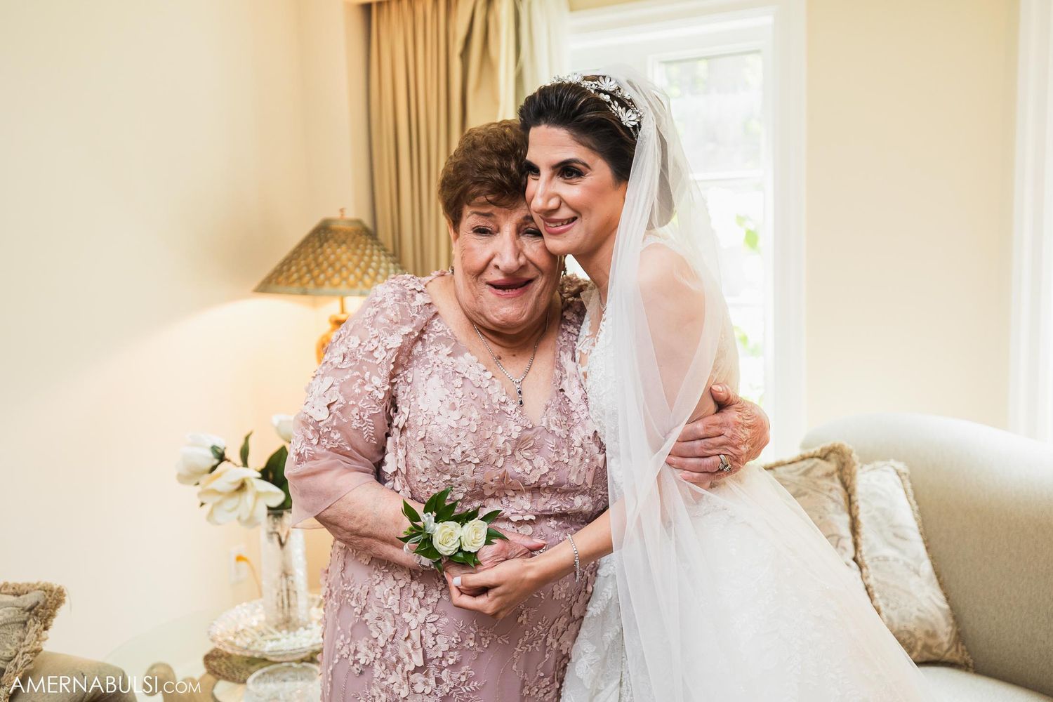 Two generations share an intimate moment in formal attire during wedding preparations.