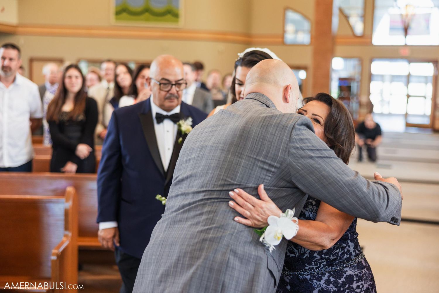 An emotional embrace shared between wedding attendees during a church ceremony.