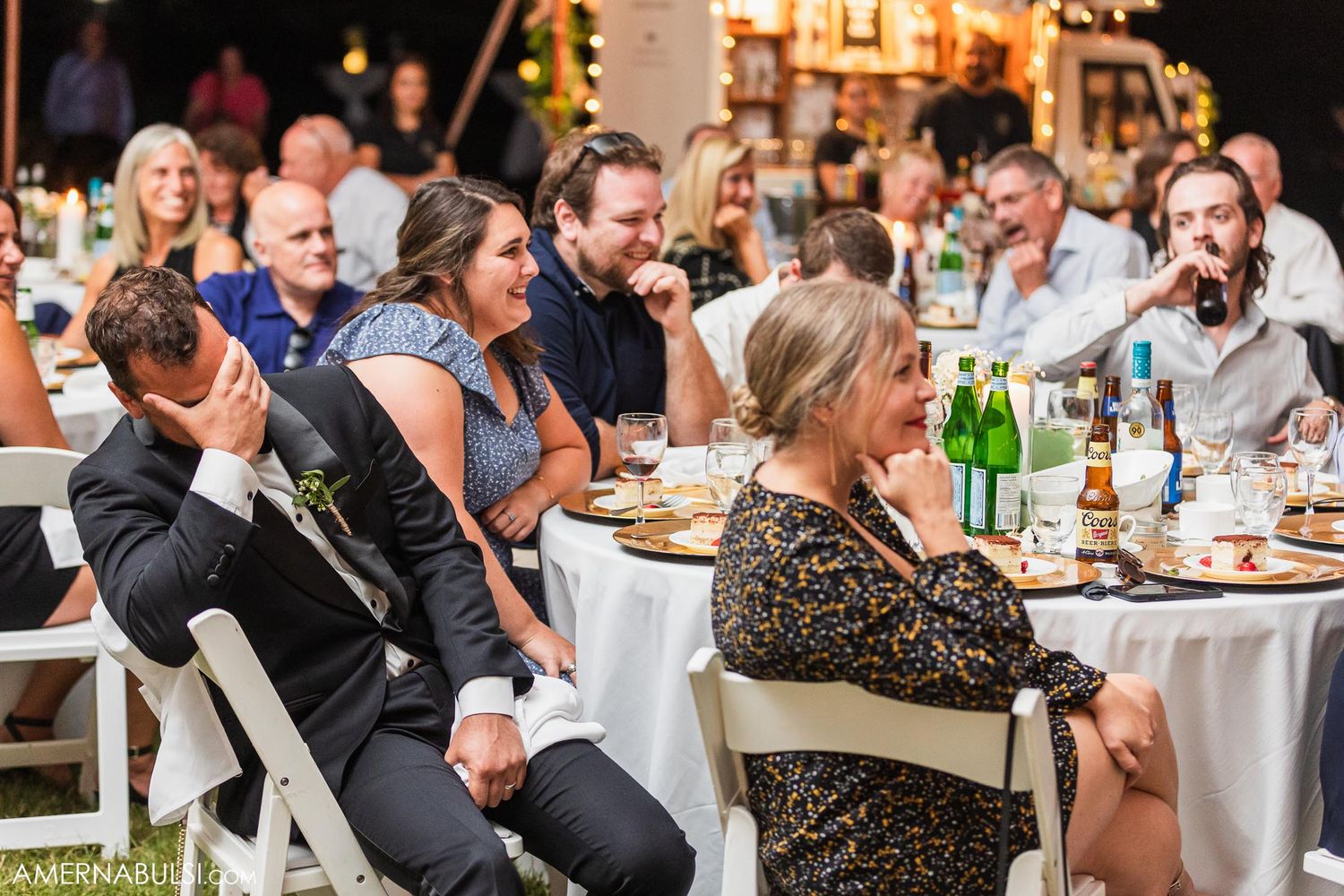 Wedding guests seated at round tables enjoying the outdoor reception celebration.