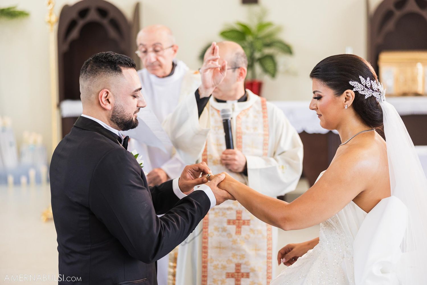 Catholic wedding ceremony with couple exchanging rings at the altar while priests officiate.
