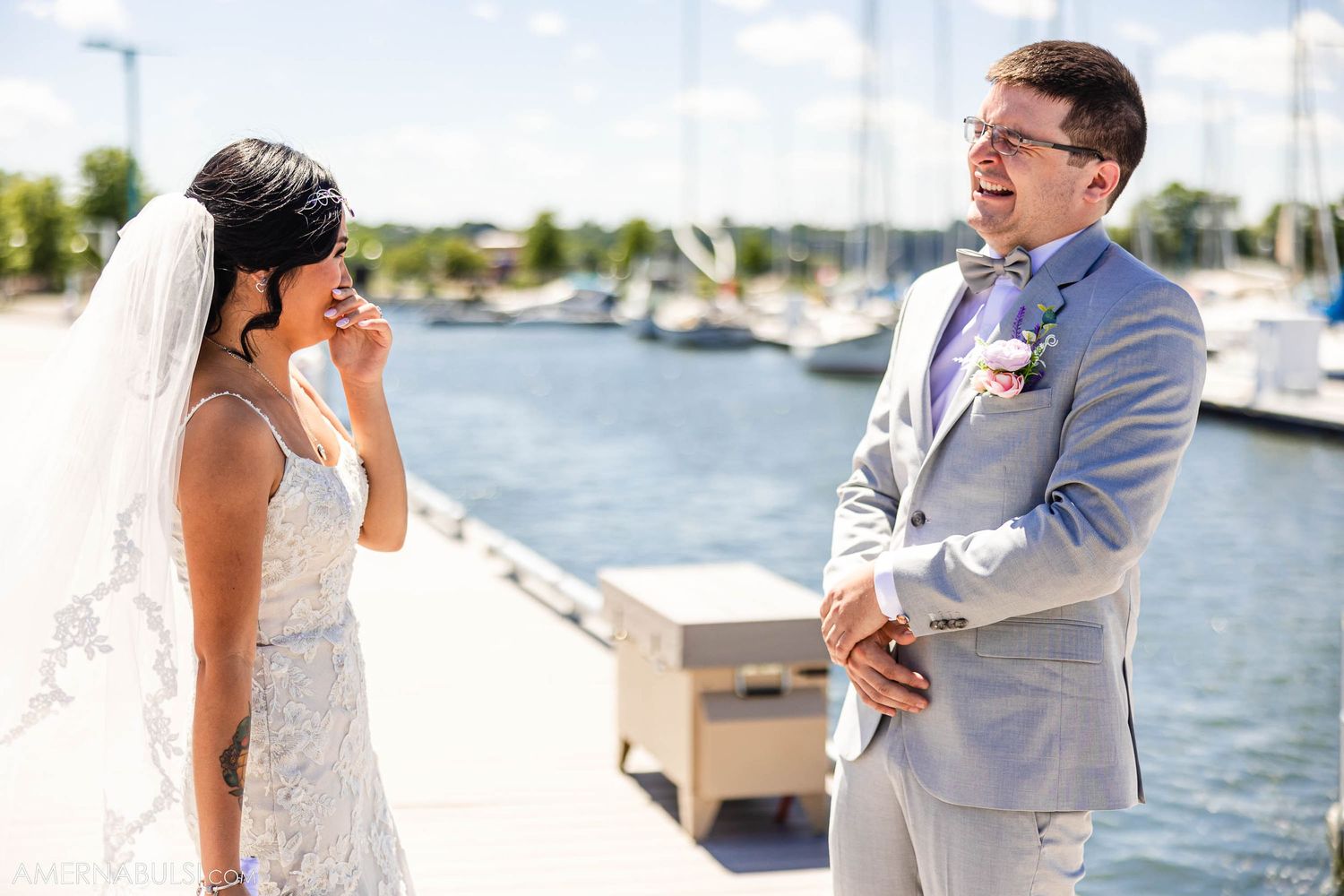 Emotional wedding ceremony moment on a waterfront dock with boats in the background.