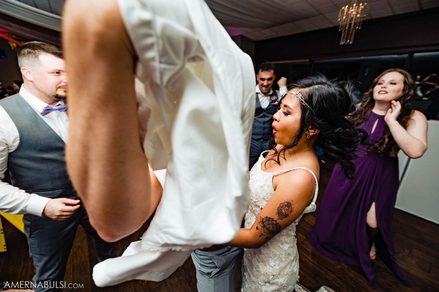 Wedding celebration with people dancing and having fun on the dance floor.