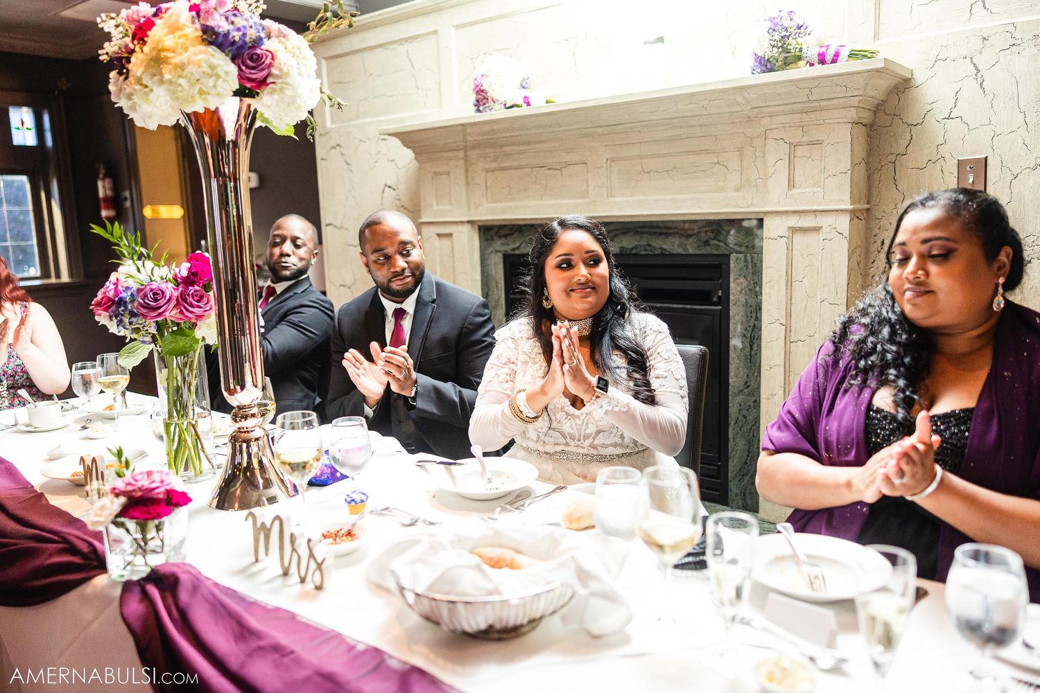 Reception guests enjoying celebration at elegant table with floral decor.