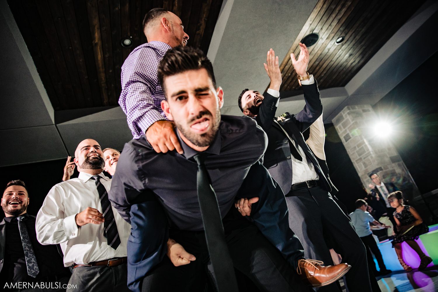 Dynamic black and white shots capture dancing party guests in dramatic lighting at a lively celebration.