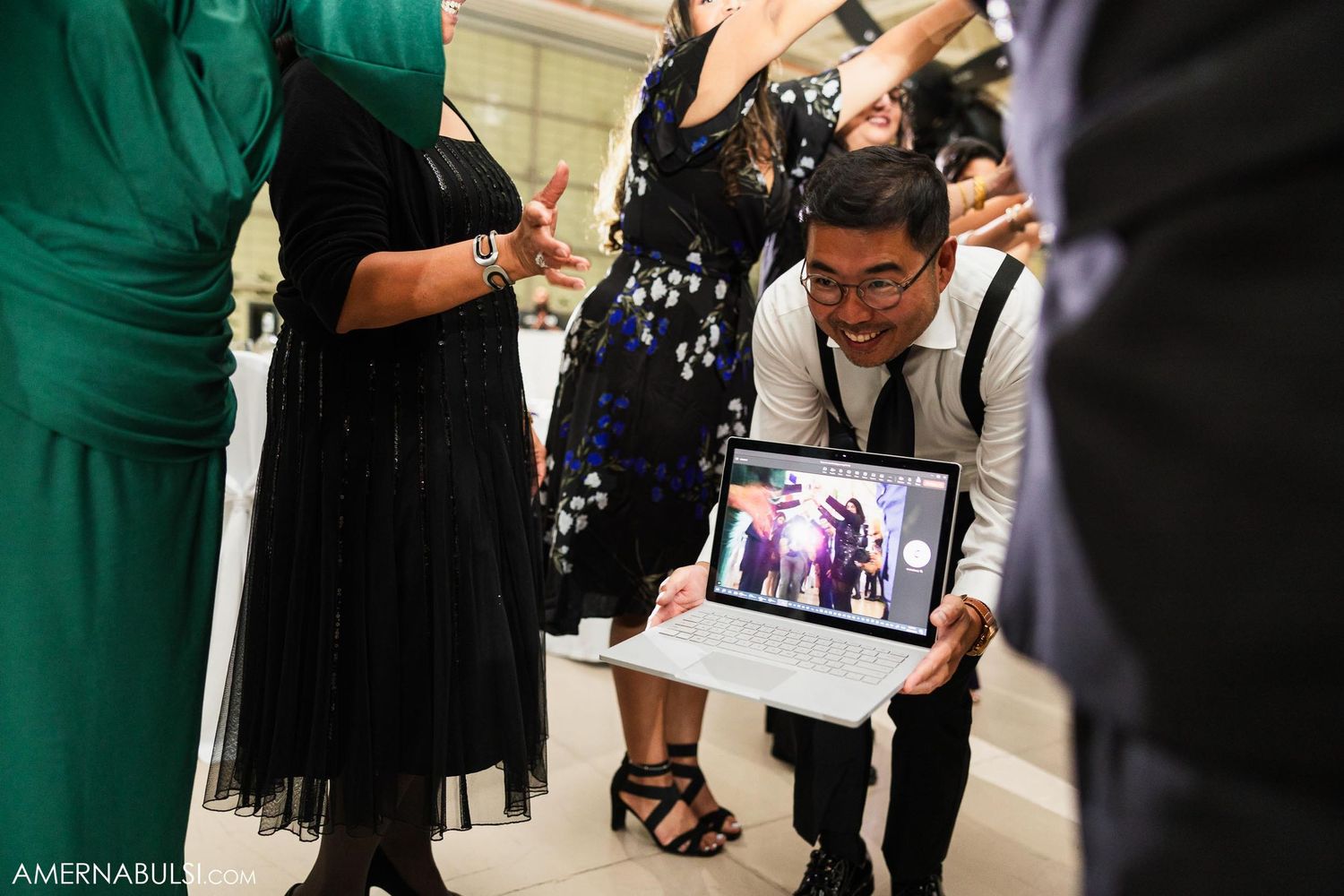Guest holds up tablet to capture moments at wedding reception.