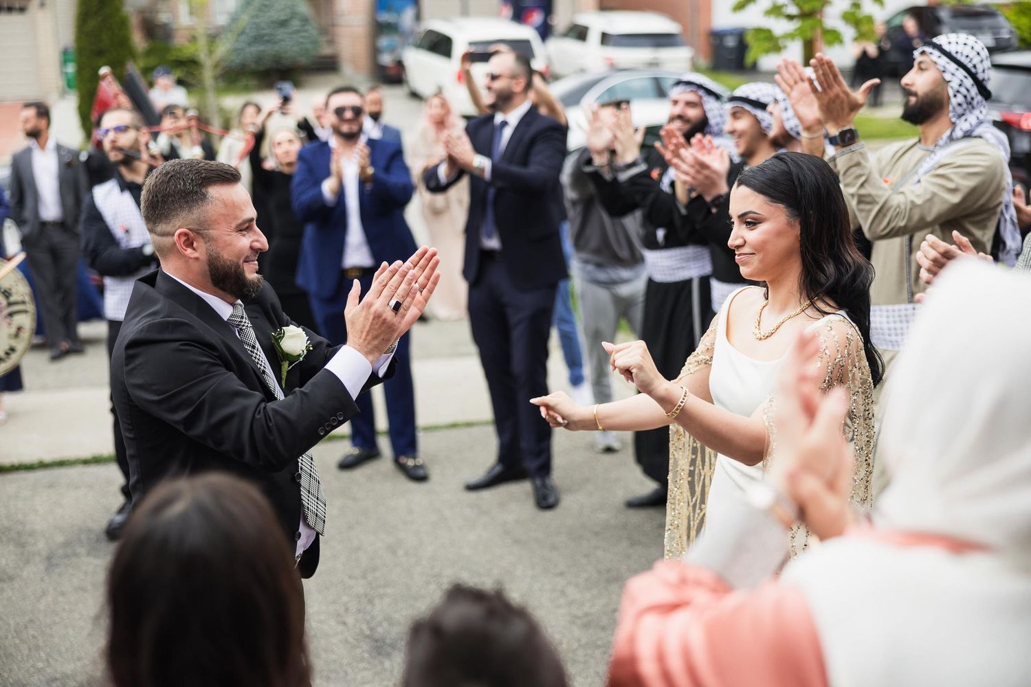 Guests clap and celebrate during an outdoor wedding ceremony.