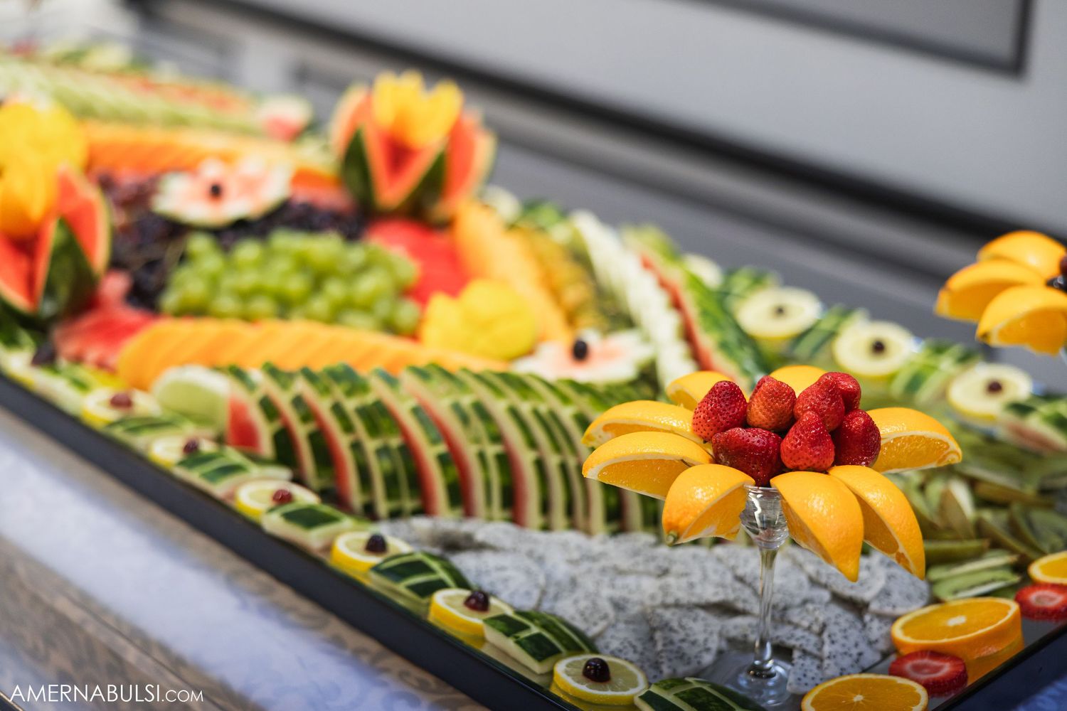 Colorful fruit and appetizer display featuring fresh berries, melons, and decorative garnishes.