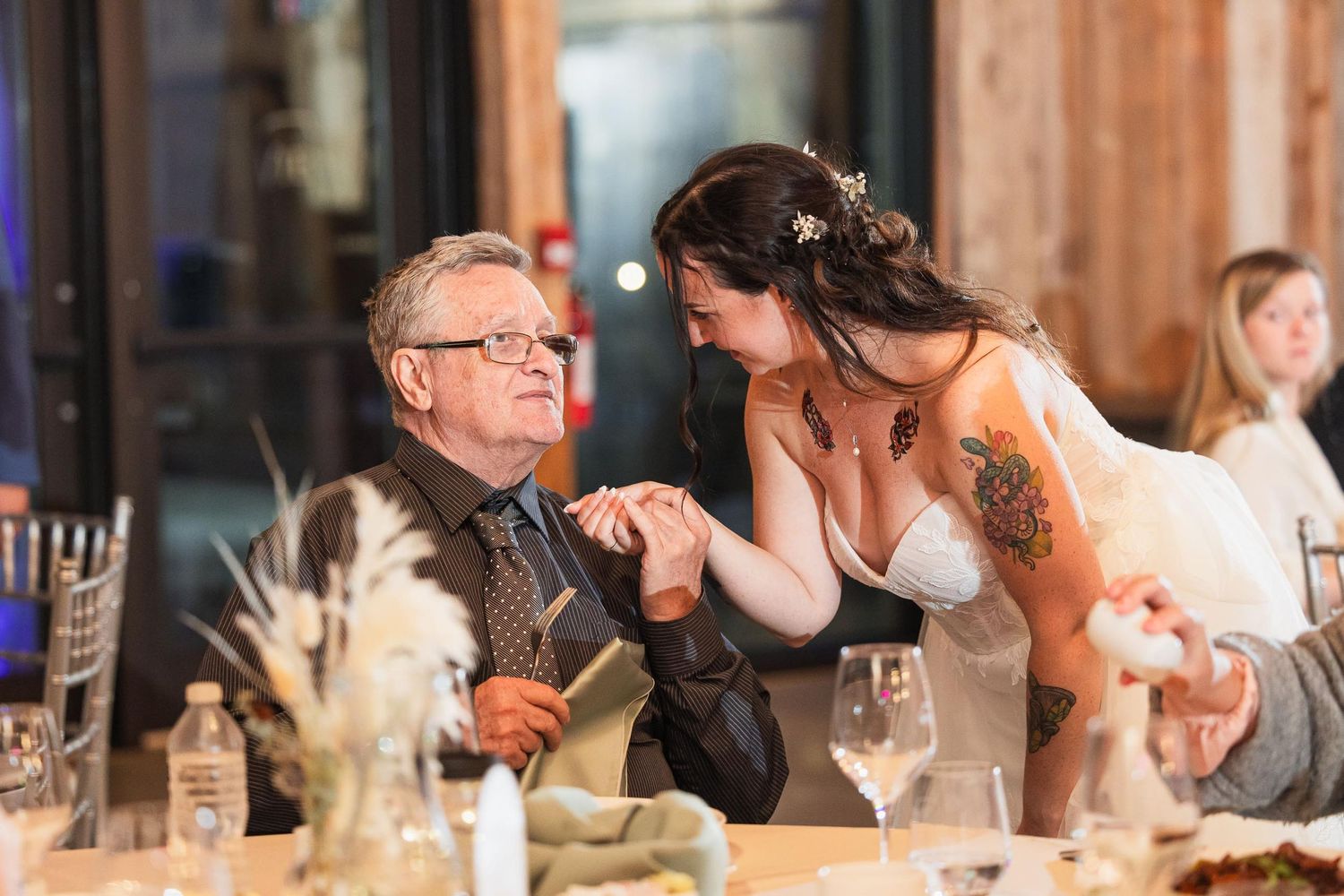 A tender moment shared between guests during a wedding reception at an elegant dinner table.