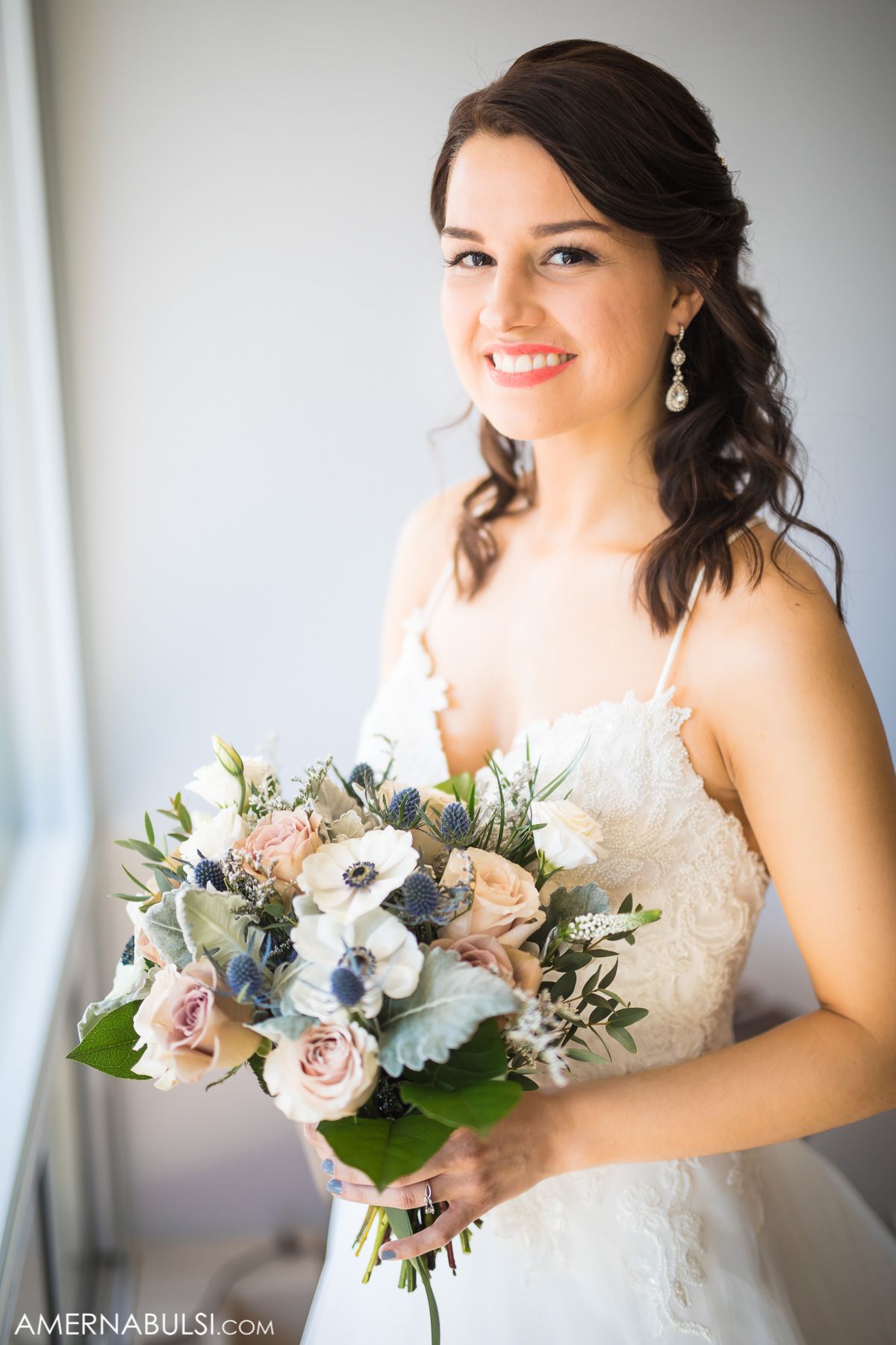Beautiful bridal portrait with delicate bouquet featuring roses and anemones.