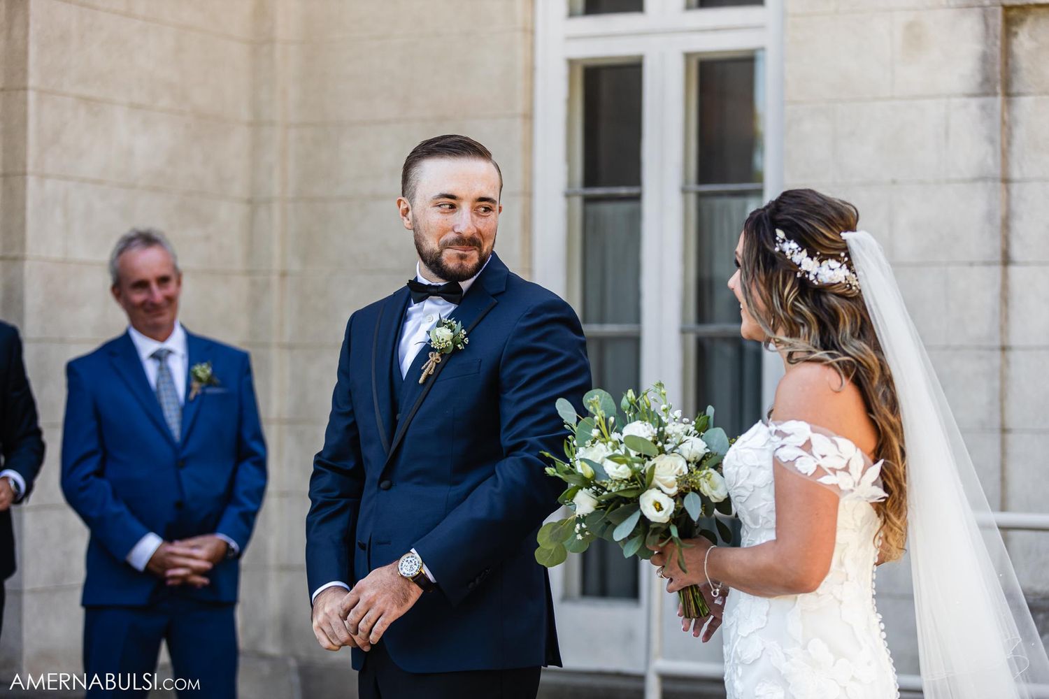 Wedding ceremony moment captured outside historic stone building.