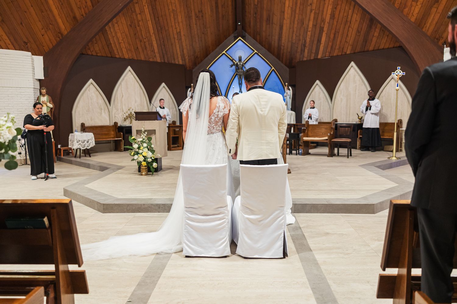 Bride and groom kneel together at the altar during their church wedding ceremony.