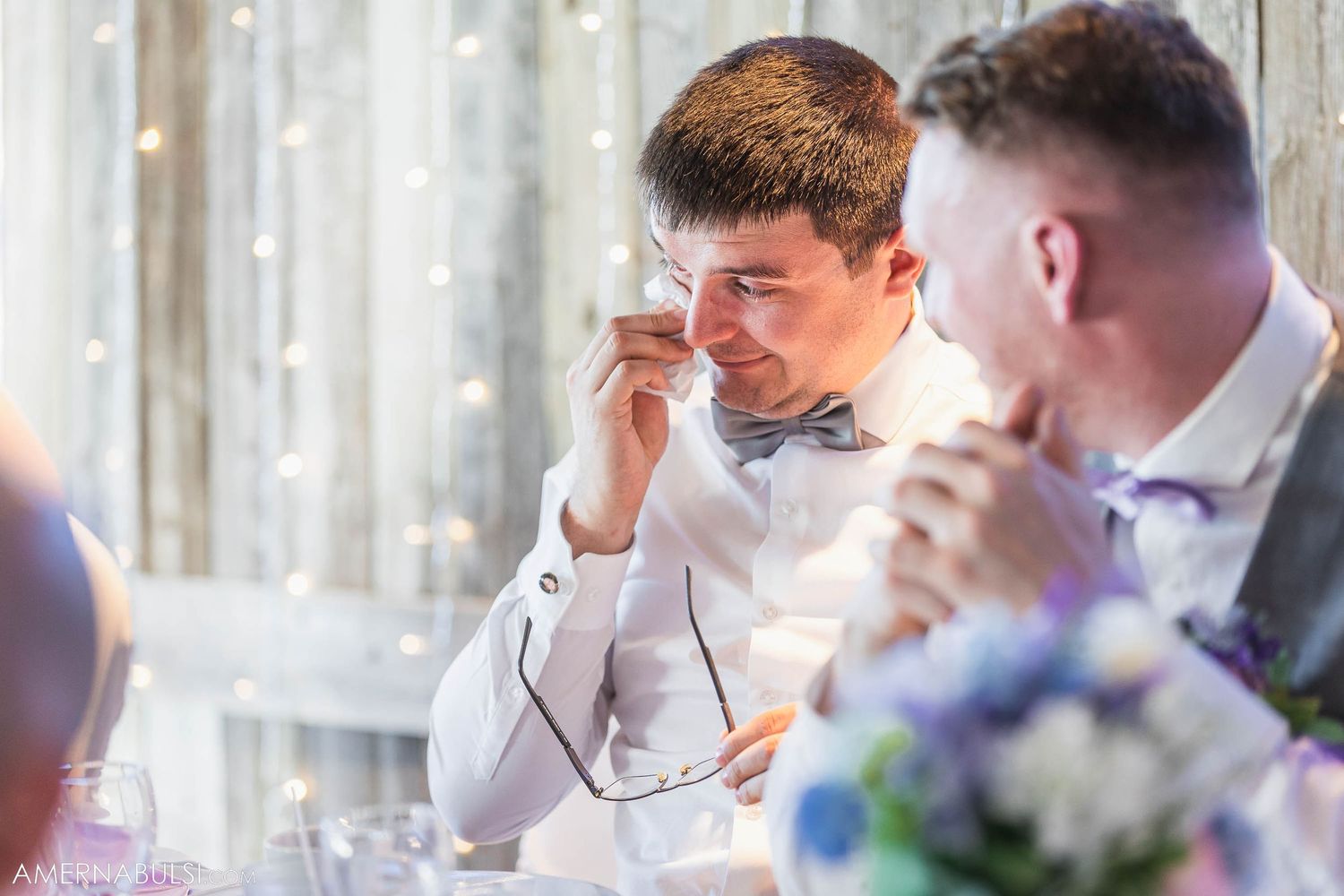 Guest wipes away tears during emotional wedding reception speech.