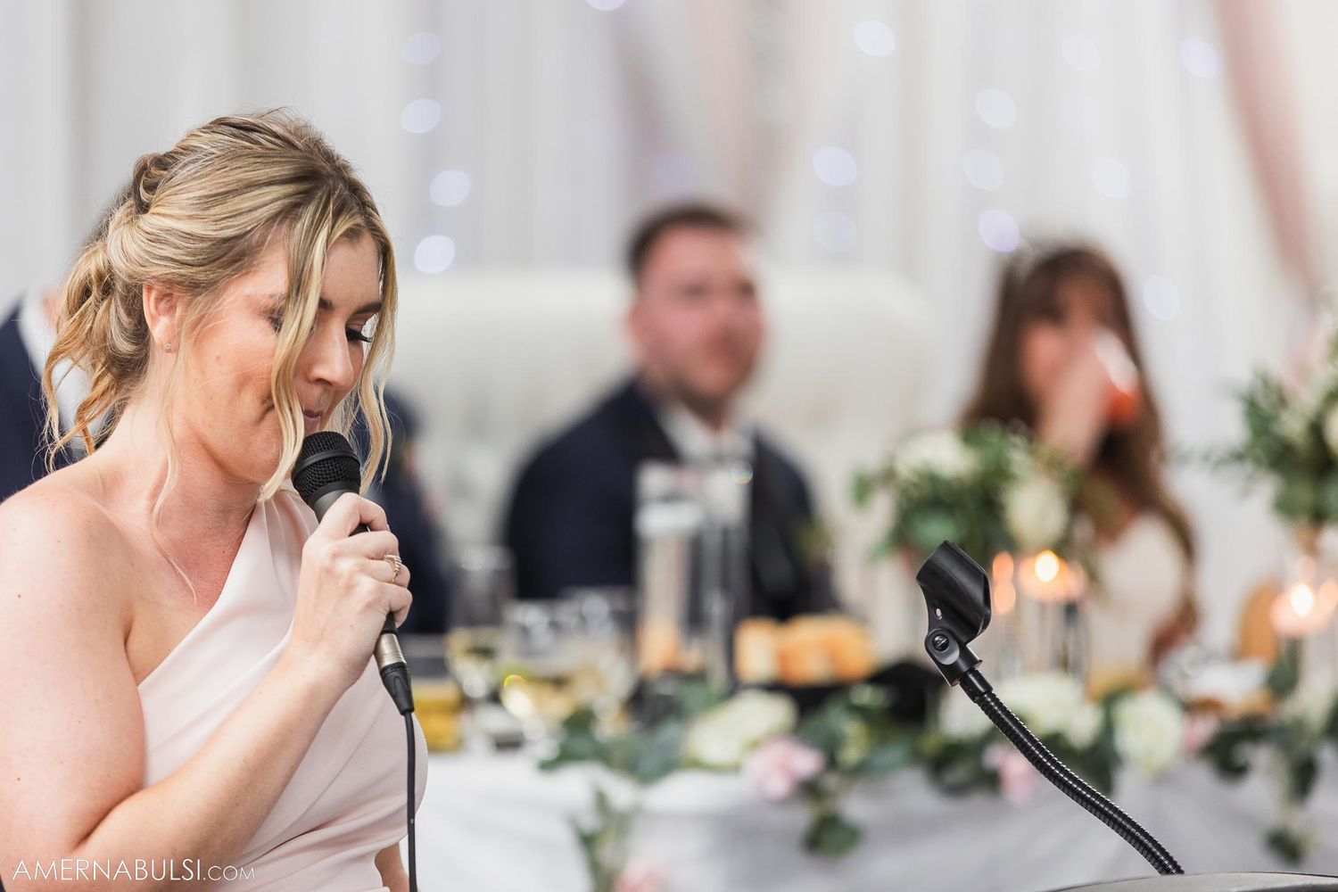 Bridesmaid delivers emotional speech at elegant wedding reception.