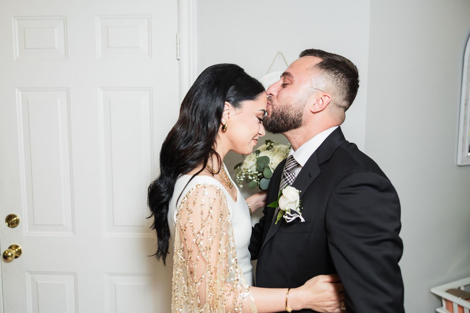 An intimate moment shared between a couple in wedding attire.