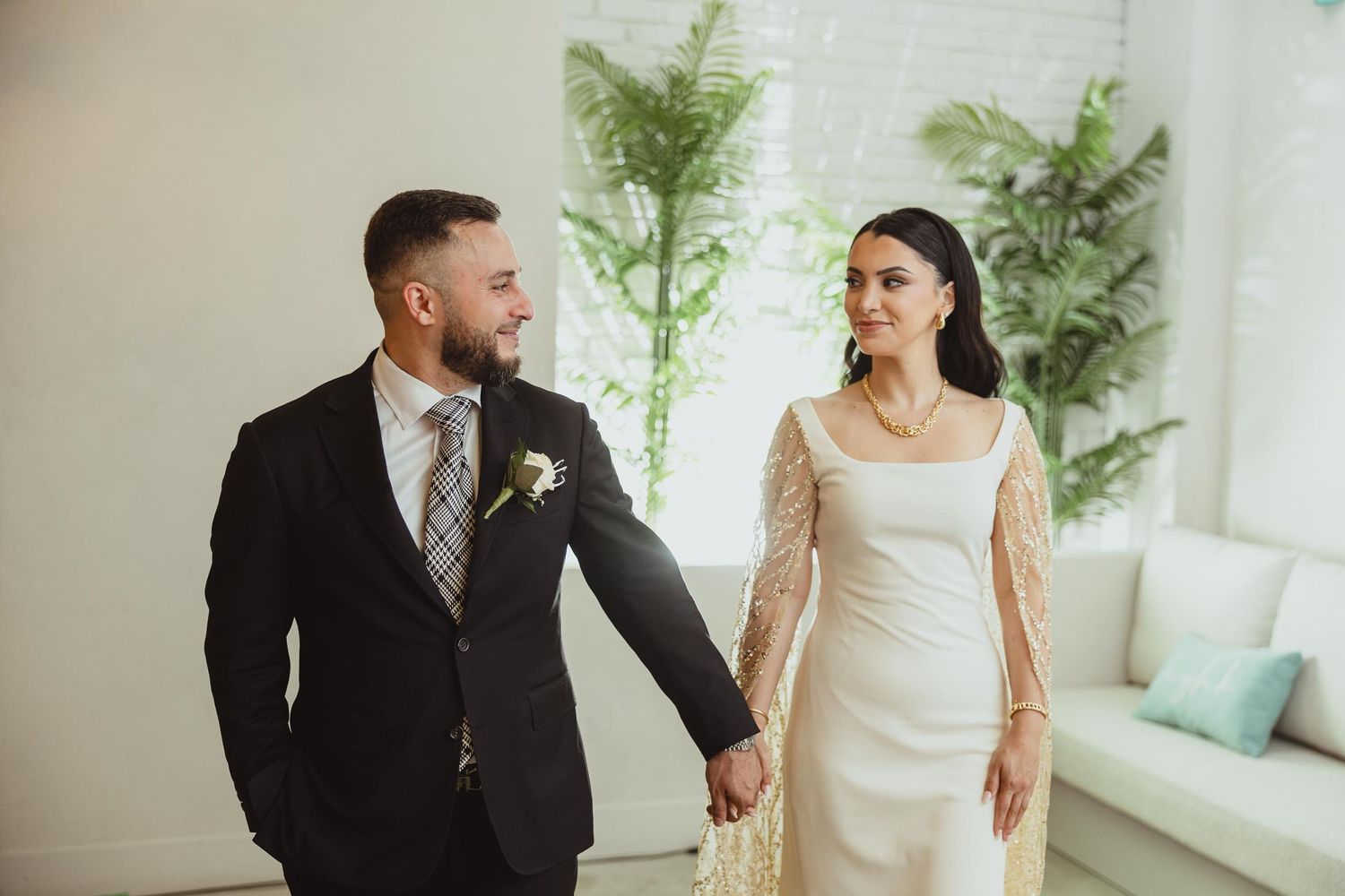 Modern wedding portrait in bright interior with minimalist greenery decor.