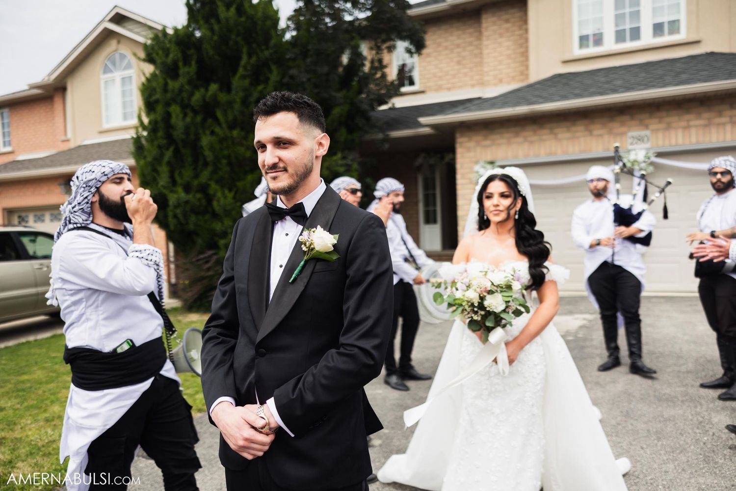 Wedding party members capture photos while bride and groom share their first look moment.