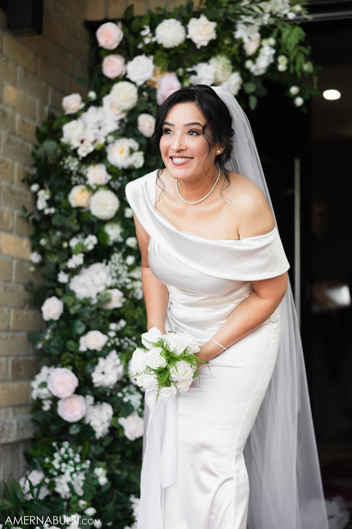 Beautiful bridal portrait with floral arch backdrop.