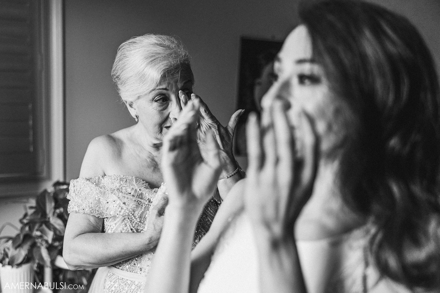 Emotional black and white photo capturing reactions during a wedding preparation moment.