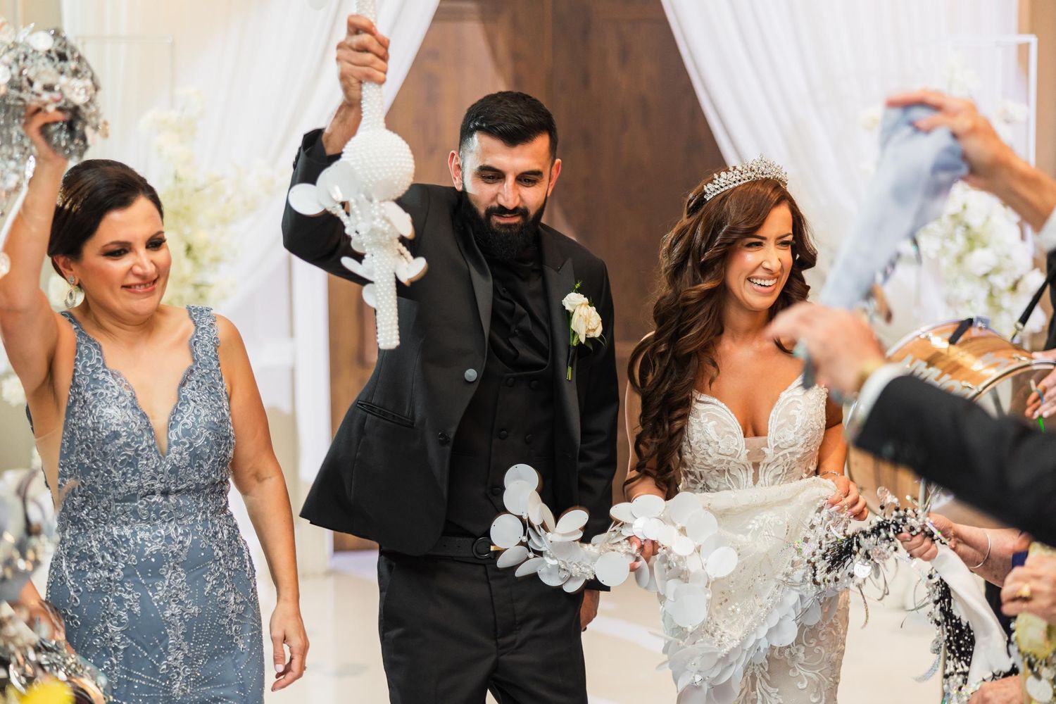 Celebratory moment at a wedding with silver and white decorations flying through the air.