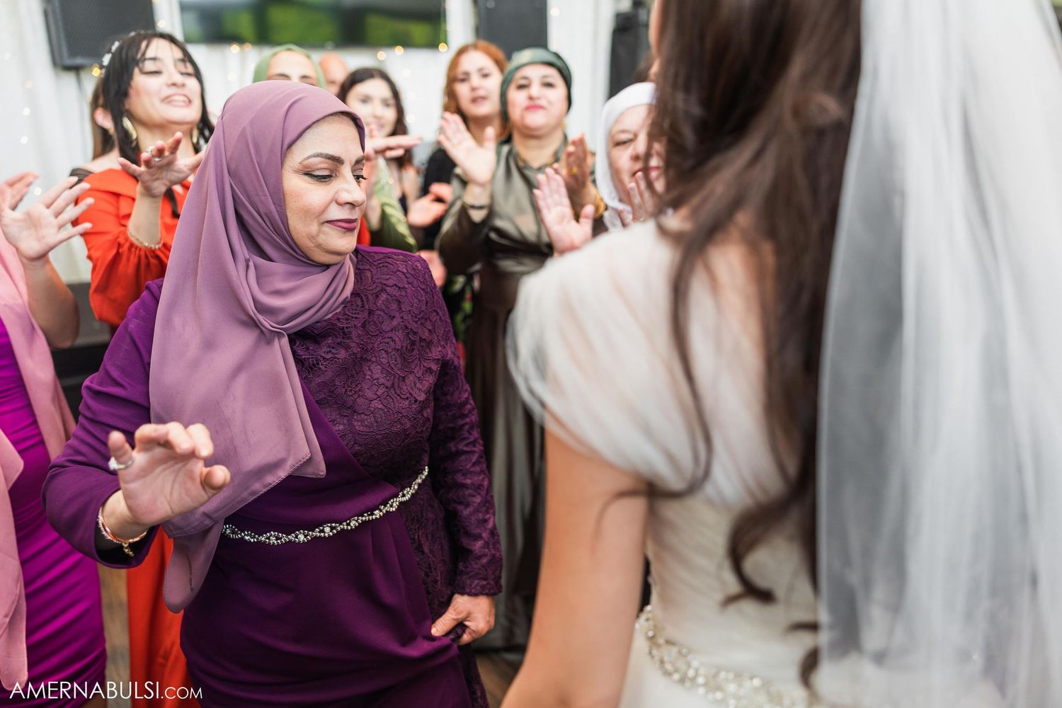 Wedding guests dancing and celebrating in colorful attire at the reception.