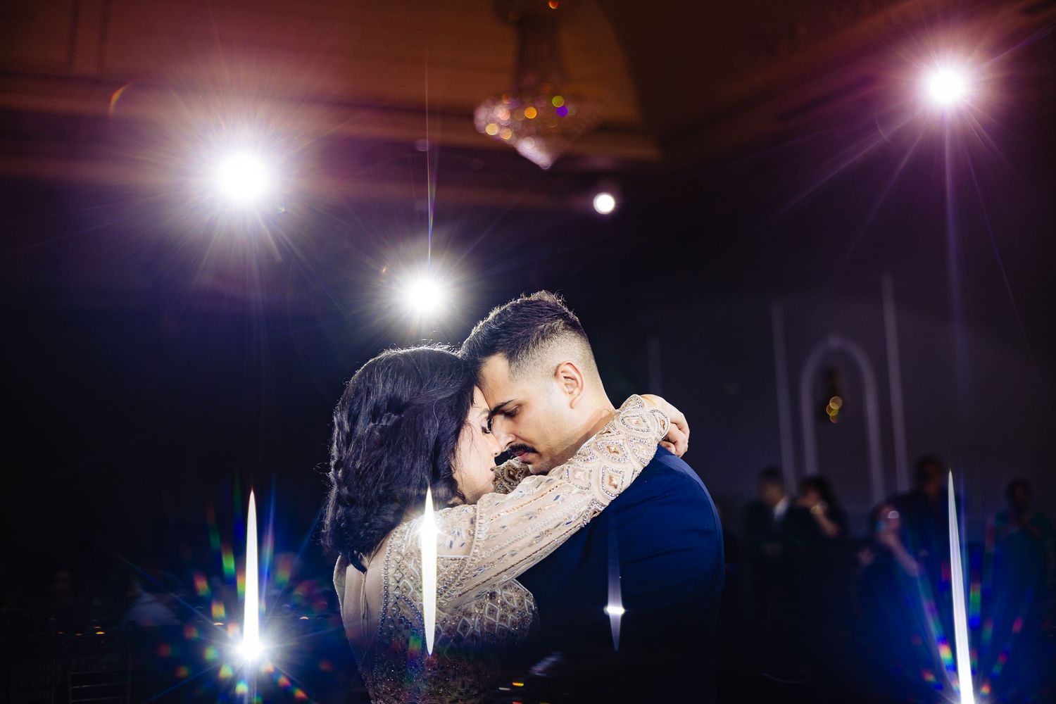 A series of romantic dance photos at a wedding reception with dramatic lighting and lens flares creating a magical atmosphere.