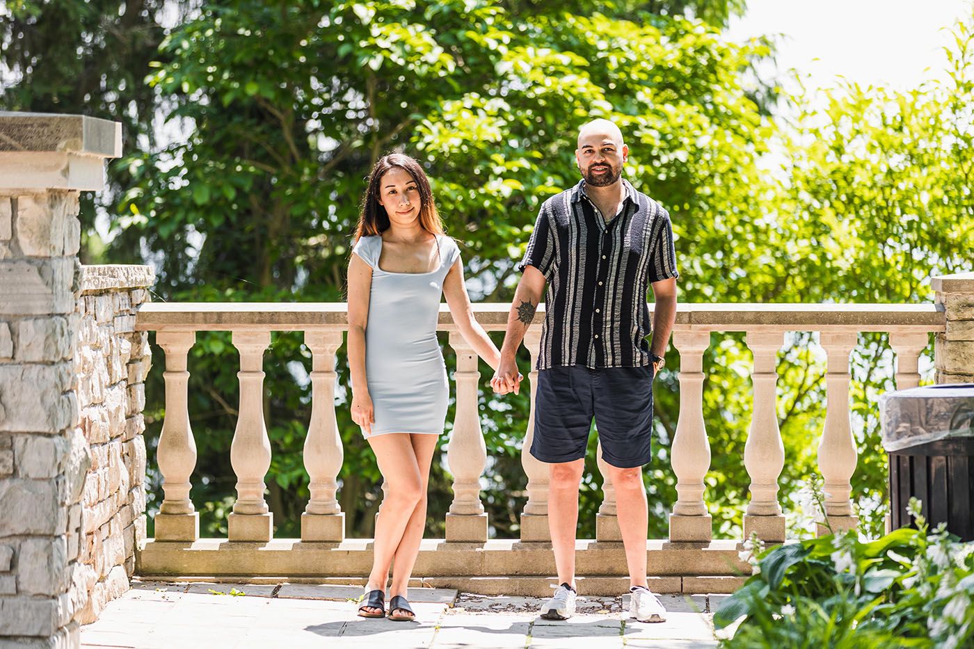 Stone balustrade and landscaping create an elegant backdrop for outdoor portraits.