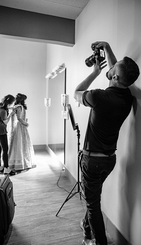 Behind the scenes photo shoot in studio with photographer capturing dress on display.
