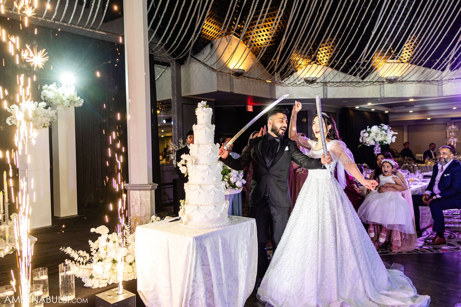 Wedding reception ballroom decorated with elegant white gowns on display and glowing chandeliers creating a romantic atmosphere.
