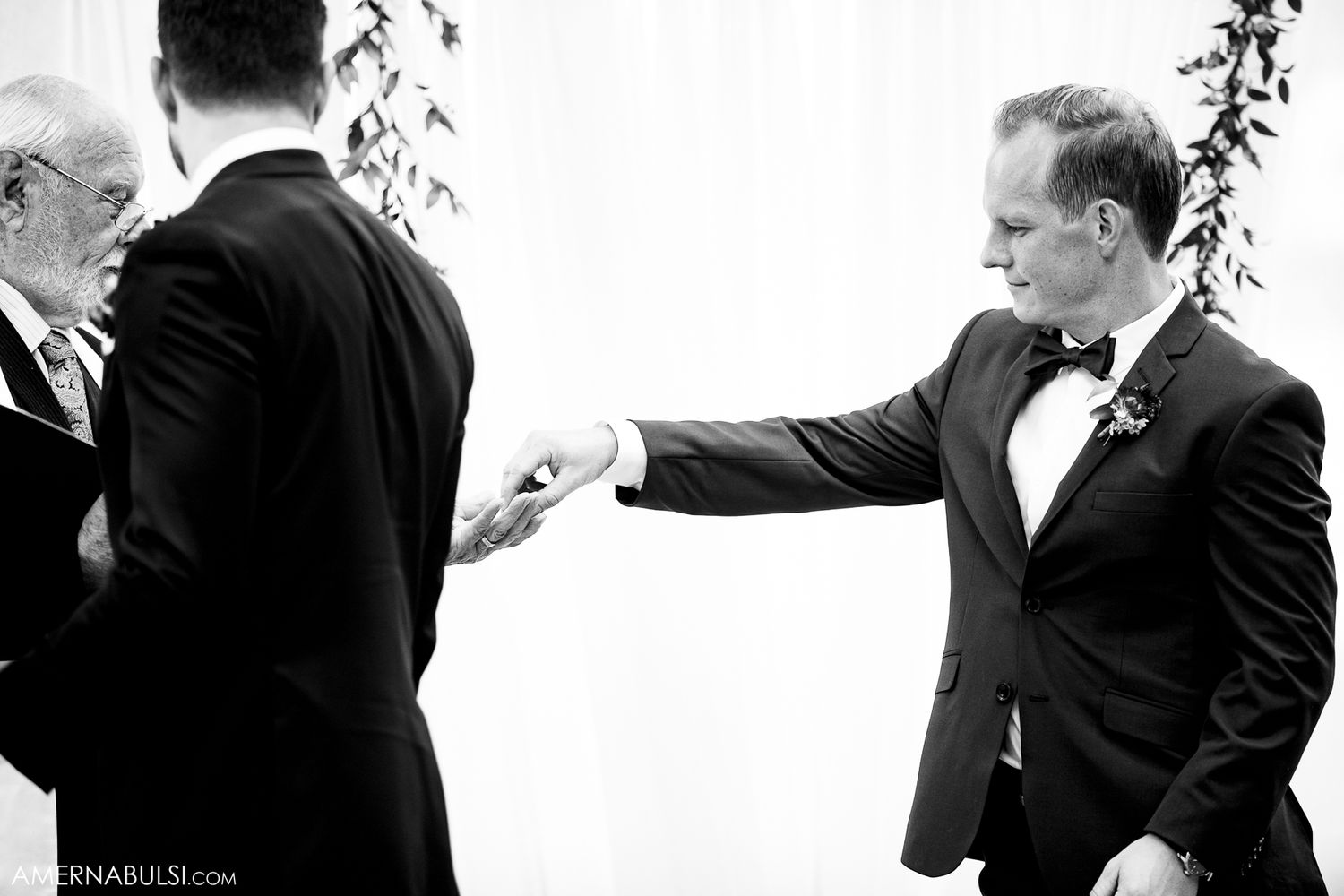 Wedding party members sharing joyful laughter during formal portraits outdoors.