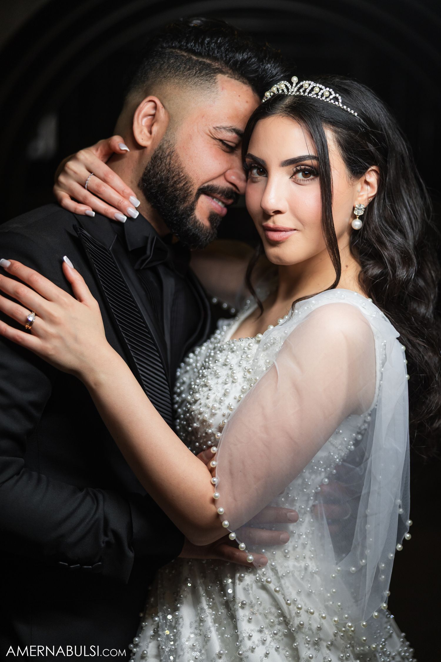 Intimate wedding portrait showcasing elegant bridal details including veil, tiara and beaded dress.