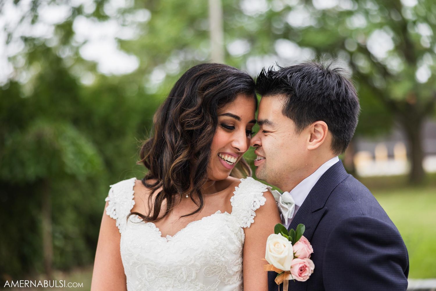 Candid outdoor wedding portrait showing couple's joyful expressions.