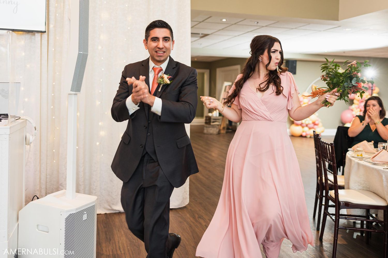 Wedding party members dance into reception hall during introductions.