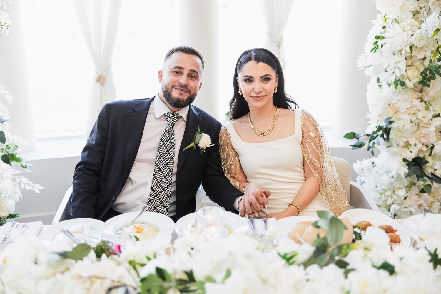 Elegant wedding reception seating with white floral arrangements and decorative elements.