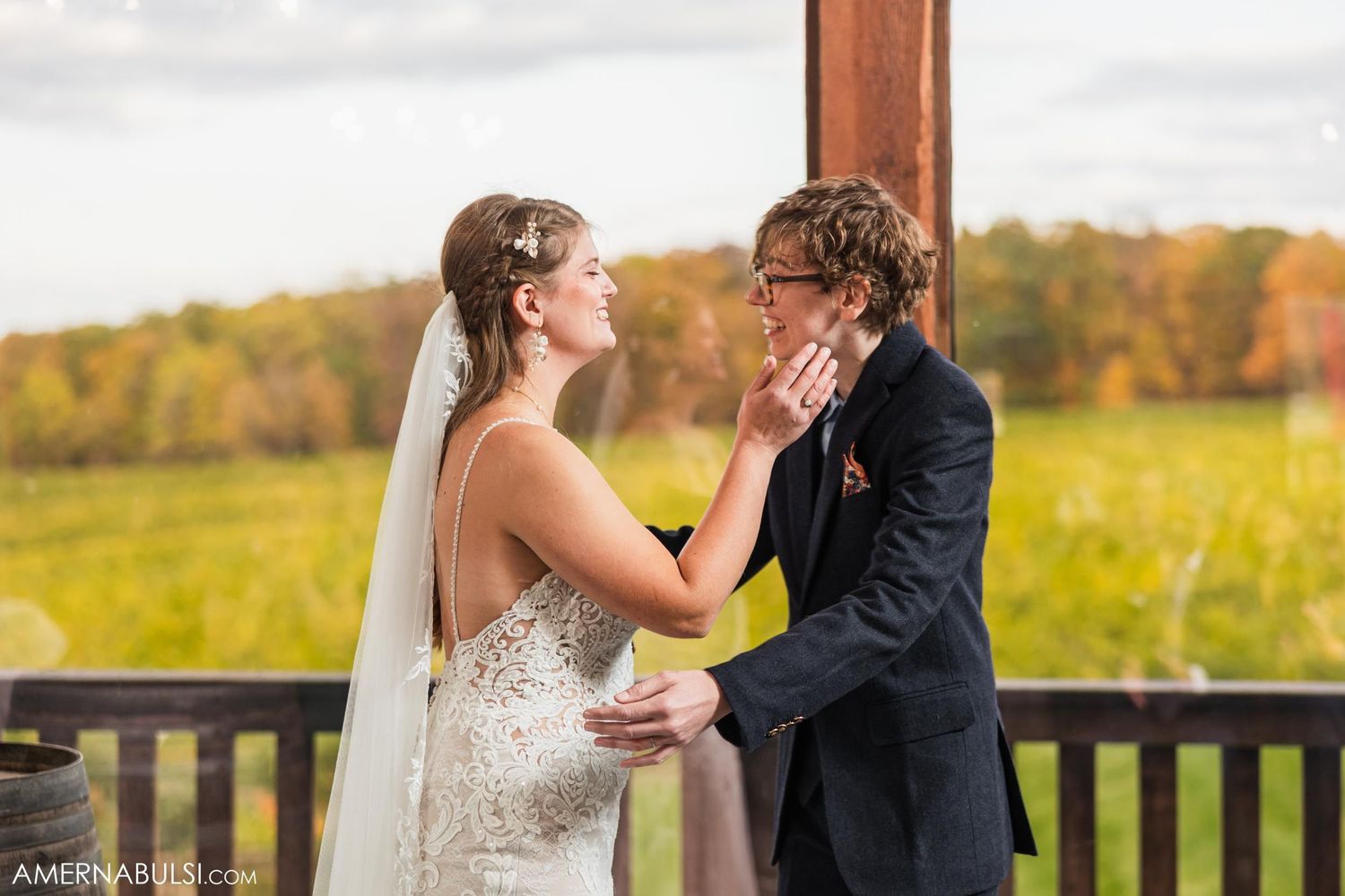 Two people share an emotional moment during their wedding ceremony on a scenic outdoor patio.