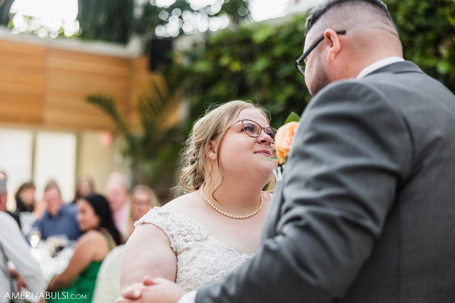 A couple dancing together in a bright indoor venue with wood paneling and skylights.