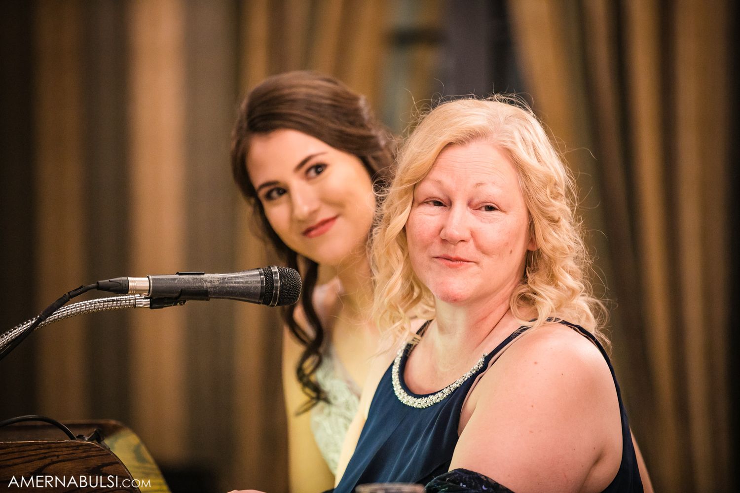 Wedding guests enjoying a celebration at round tables in an elegant ballroom setting.