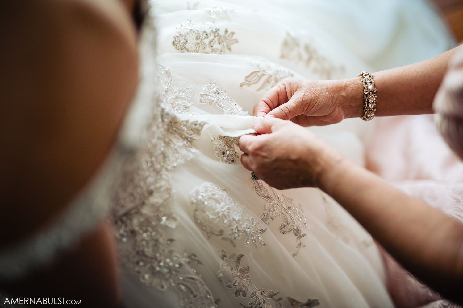 Intricate beadwork and lace details on a white wedding gown.