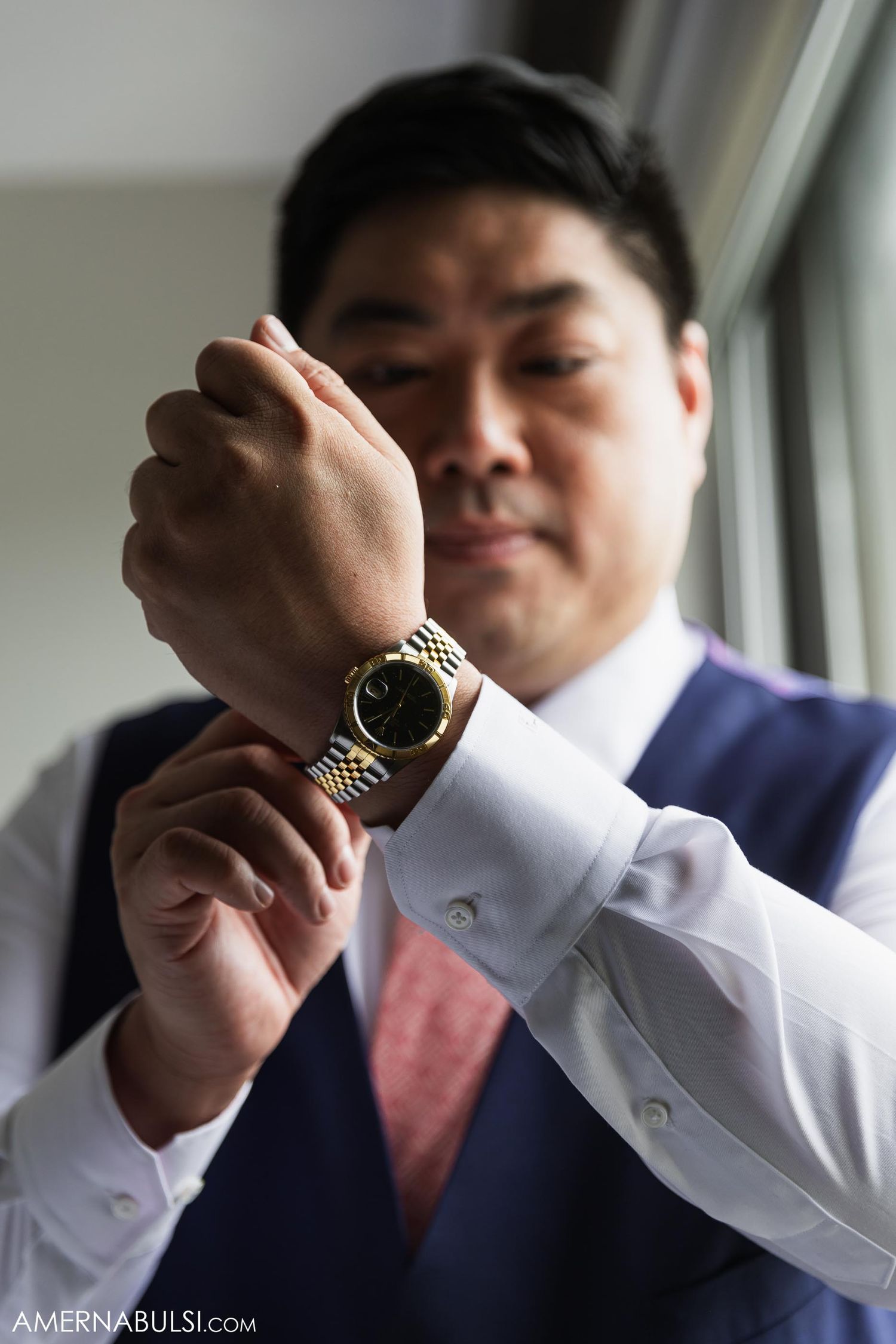 Close-up shot of a luxury watch being adjusted on a wrist.