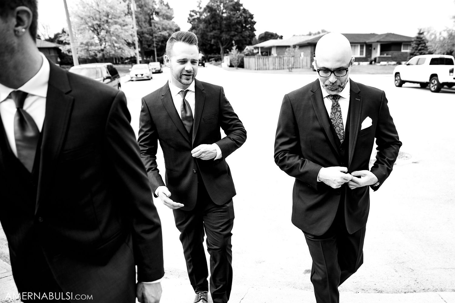 Black and white candid shots of groomsmen walking and laughing together outdoors.