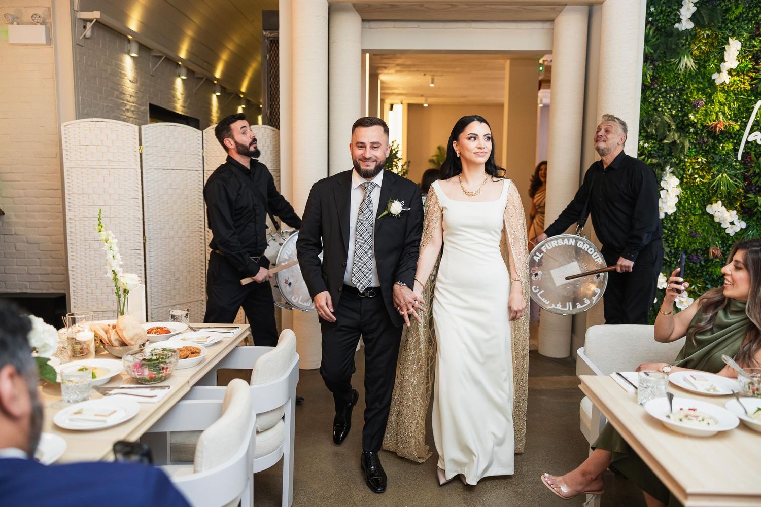 Wedding reception entrance with guests seated at dining tables.