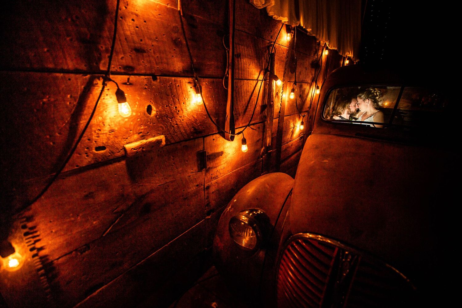 Moody evening scene with string lights creating warm ambiance against rustic wooden walls.