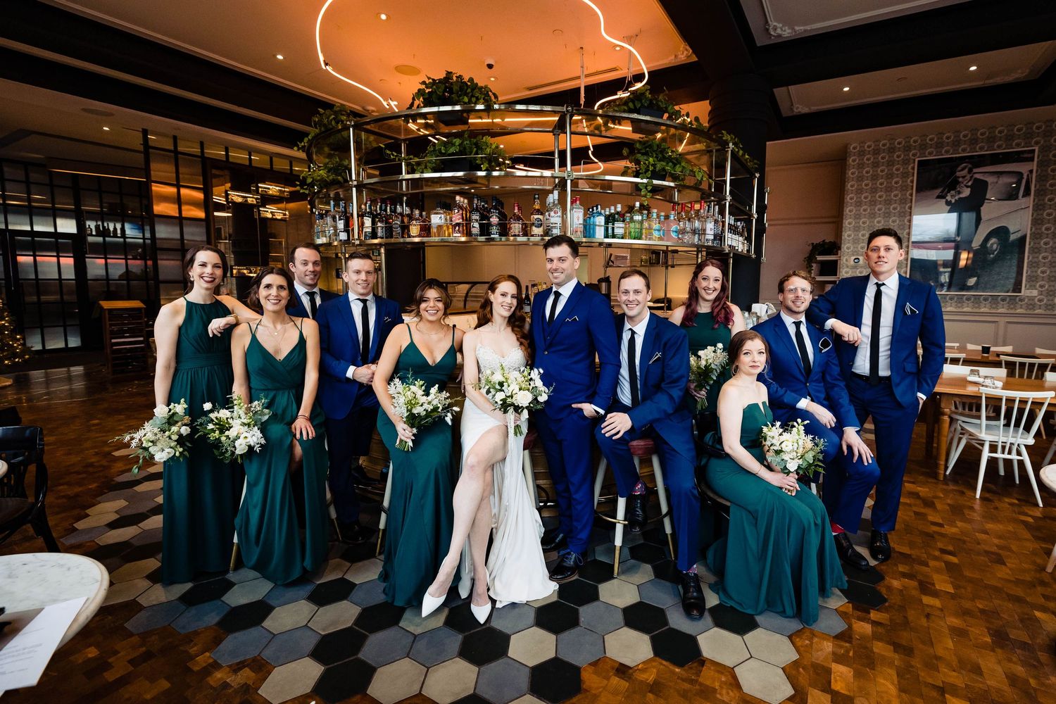 Wedding party celebrates in rustic indoor venue with exposed brick and warm lighting.