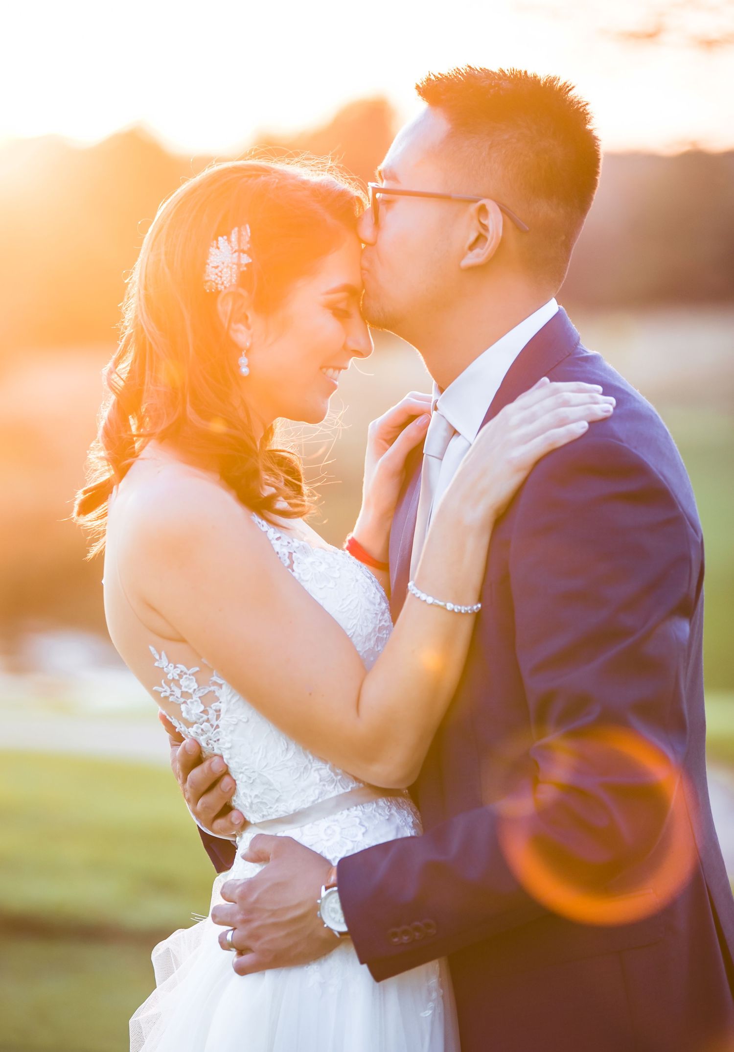 Intimate sunset portrait of newlyweds sharing a tender moment.