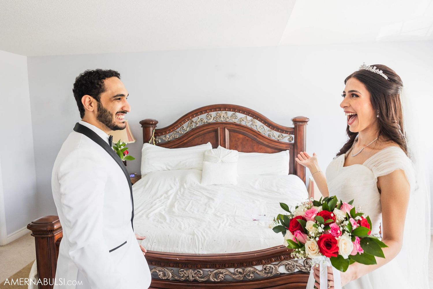 A candid wedding moment captured between a couple near a wooden headboard.